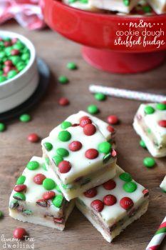 M&M Cookie Dough Stuffed Fudge is an easy, delicious recipe thats perfect for the holidays. This 5 minute fudge is made with white chocolate stuffed with an M&M cookie dough and topped with more M&M's! A crowd pleaser and a great gift!