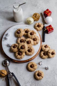 Peanut Butter Blossoms on a round serving tray with milk and Hershey's kisses.