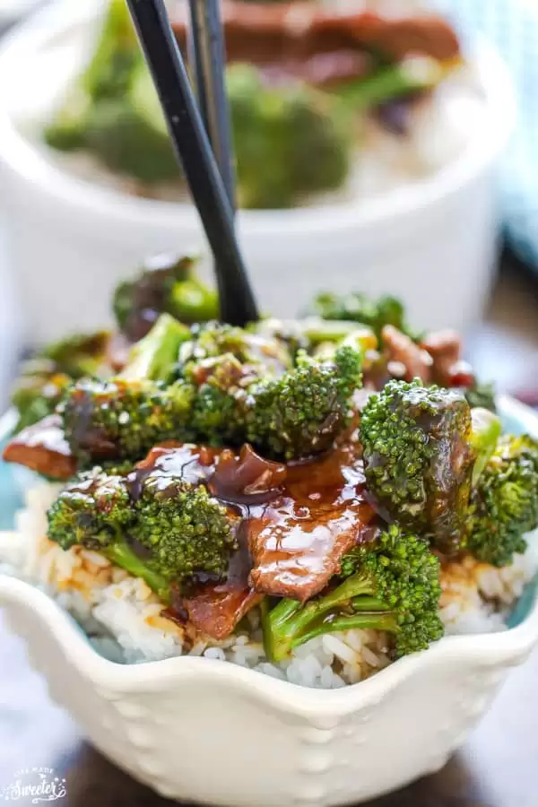 Delicious Broccoli & Beef Rice Bowls with black chopsticks.